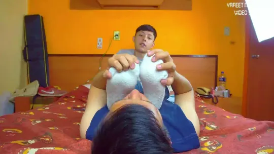 Mi esclavo me quita los calcetines en la cama y lame mis pies